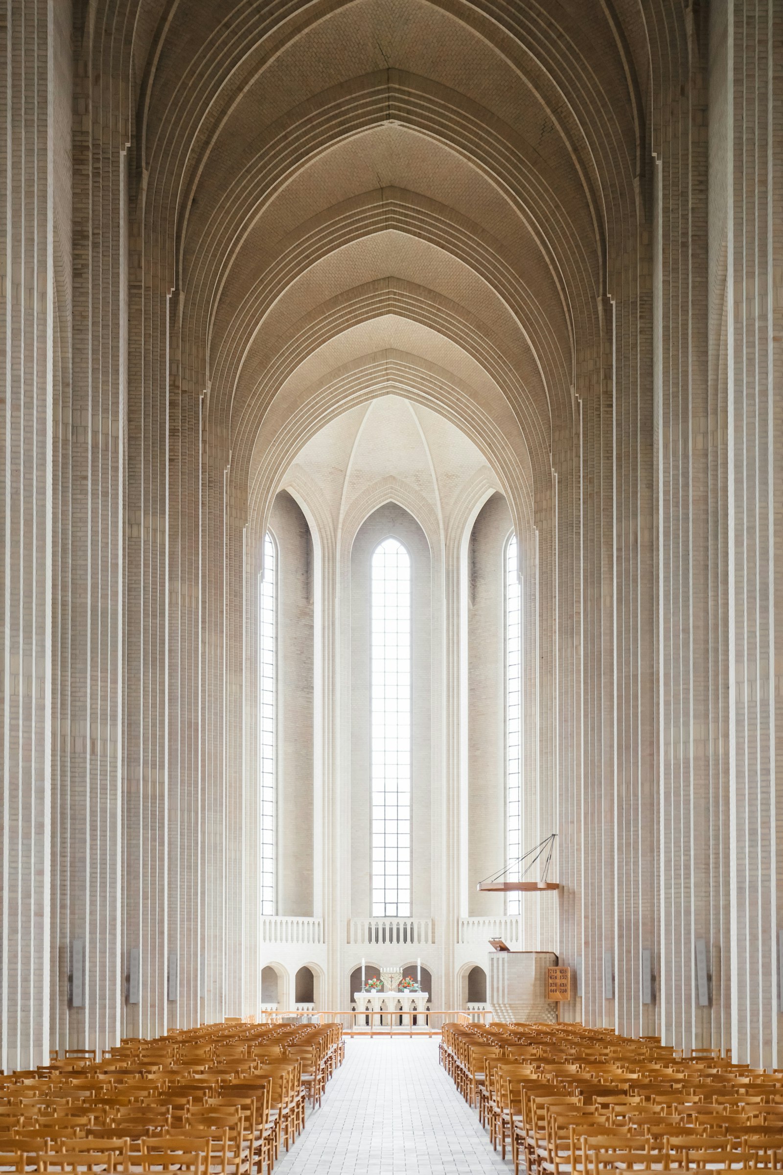 Vaulted masonry hall, ribs converging into shadow